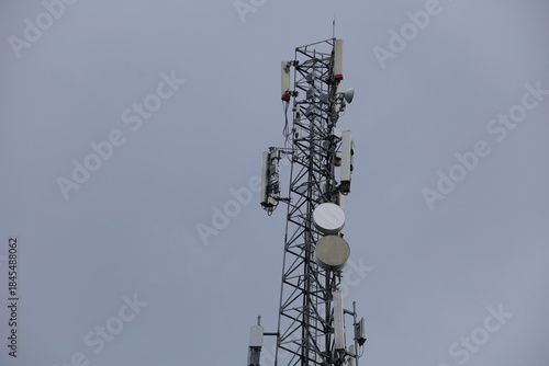 Wireless communication technology uses a steel tower with a cell phone antenna for radio signal transmission to the mobile network in the blue sky