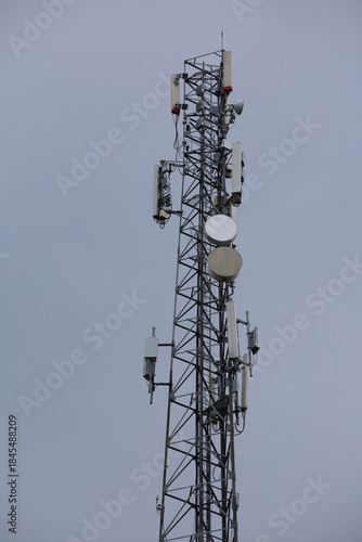 Wireless communication technology uses a steel tower with a cell phone antenna for radio signal transmission to the mobile network in the blue sky