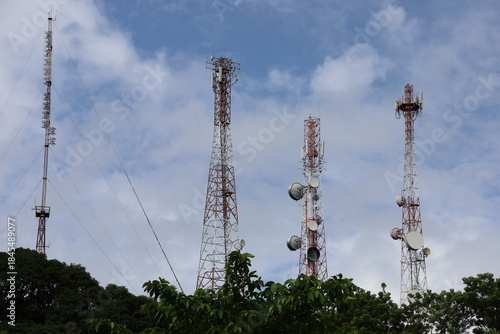Tower crane and communication antenna on a steel structure construction site against a blue sky, representing wireless telecommunication network technology and the building industry