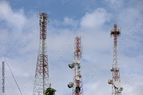 Tower crane and communication antenna on a steel structure construction site against a blue sky, representing wireless telecommunication network technology and the building industry