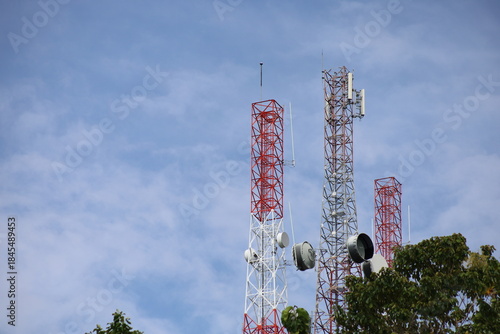 Tower crane and communication antenna on a steel structure construction site against a blue sky, representing wireless telecommunication network technology and the building industry