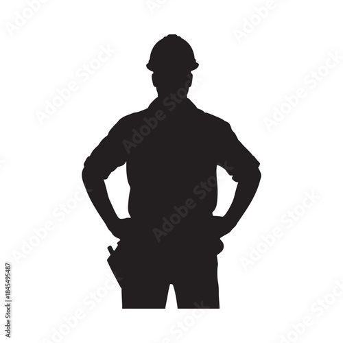 Silhouette of a construction worker standing with hands on hips a stark image