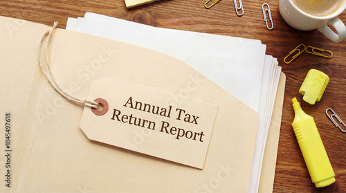 Annual tax return report filing documents on office desk with manila folder papers coffee and office supplies for business accounting financial compliance and year end preparation