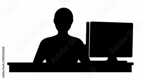 Silhouette of a person working on a computer in a modern office setting
