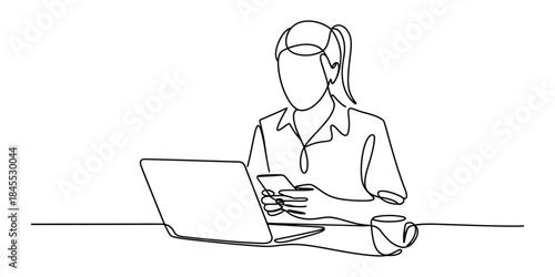 Woman working on laptop and using smartphone at desk