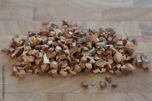 A Close-Up View of Chopped Oak Bark Pieces Displayed on a Wooden Surface, Highlighting Their Texture and Earthy Colors