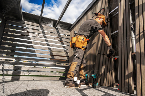 Worker Builds Structure in Outdoor Space During Daytime