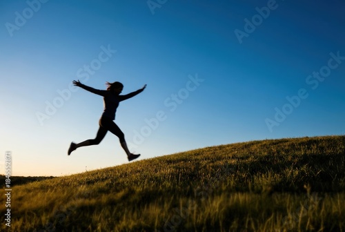 Wallpaper Mural Silhouette of a person jumping on a grassy hill at sunset. Torontodigital.ca