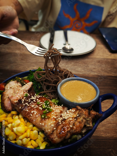 Grilled chicken salad with fresh vegetables and pasta.