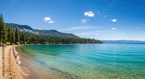 Sandy beach meets crystal water with a mountainous, forested shoreline under a bright blue sky