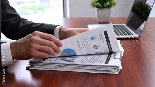 Hands reviewing printed business documents on desk