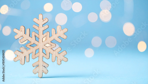 Wooden snowflake ornament on softly blurred blue background, festive winter holiday, Christmas