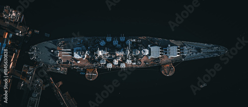 Aerial view of a battleship sits anchored in dark waters, its weathered deck a testament to time and conflict, Fall River, Massachusetts, United States.