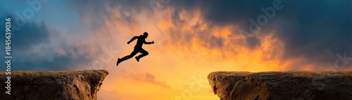 Wallpaper Mural A silhouette of a person leaps across a gap, set against a vibrant sunset sky, symbolizing courage and determination. Torontodigital.ca