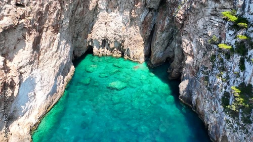 Aerial drone cinematic video of tropical exotic seascape ideal for snorkeling with sea caves and white limestone rocks resembling a blue lagoon