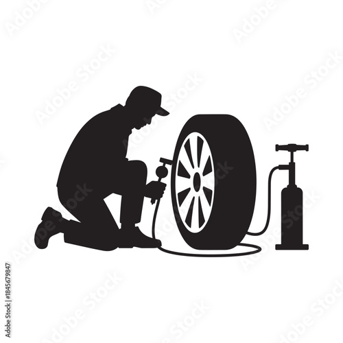 Silhouette of a mechanic inflating a tire with an air compressor