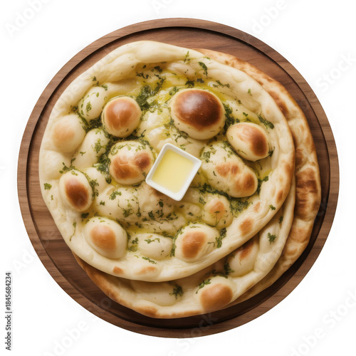 An overhead shot of delicious garlic naan flatbread served fresh on a round wooden board isolated on transparent background