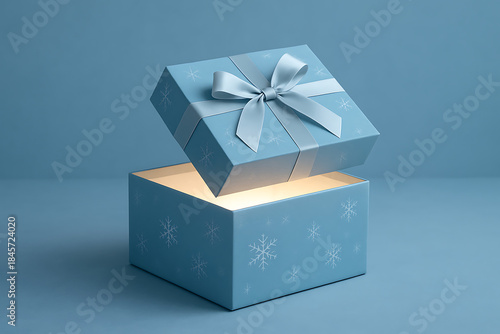 Blue christmas gift box with snowflakes open revealing light on blue background holiday season celebration mockup