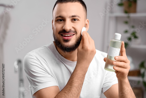 Smiling man applying facial...