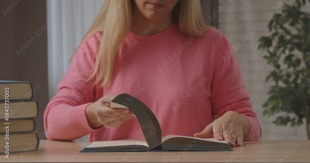 Naklejka premium Woman Reading Book at Wooden Table Indoors