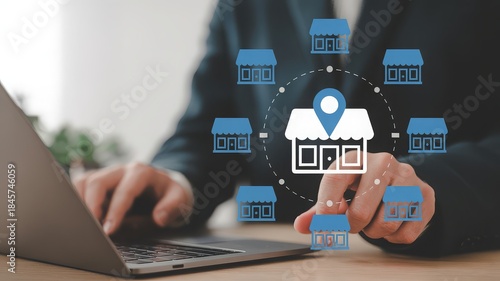 A person using a laptop to manage a franchise business with multiple locations represented by icons.