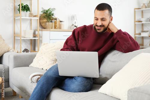 Young man using laptop on s...