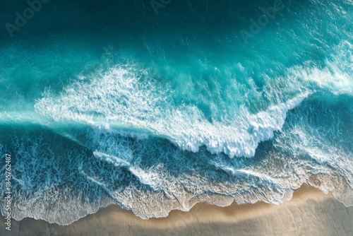 Captivating Aerial View of Turquoise Ocean Waves Crashing Gently Against the Shoreline in a Sunny Coastal Landscape