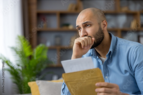 Canvas-taulu Young man reading important document, feeling stressed and anxious about an unex