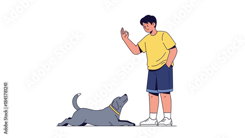 A young man is training his dog, the dog is lying on the ground looking up