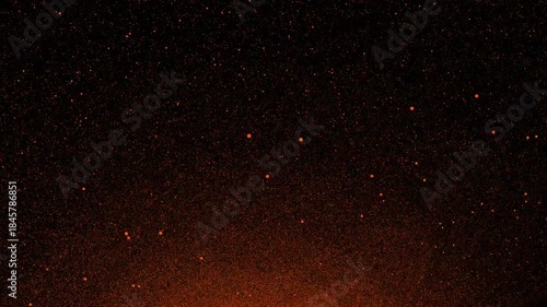 Abstract space background with orange particles floating in starry night sky