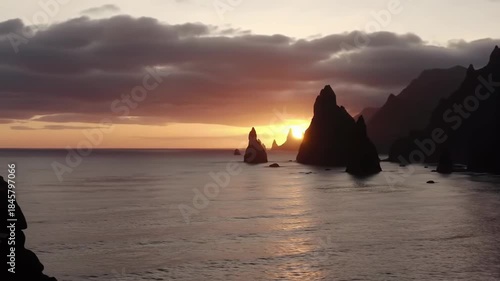 Sunset bathes coastal rock formations in light, serene ocean views