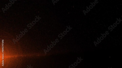 Abstract orange light effect with particles in dark space background