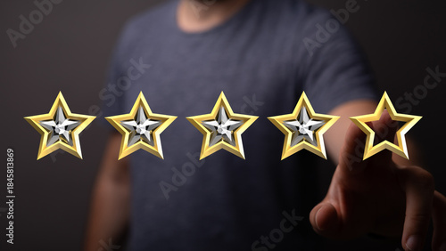 Photos A person's hand selecting a glowing golden star, giving five stars for great review or rating