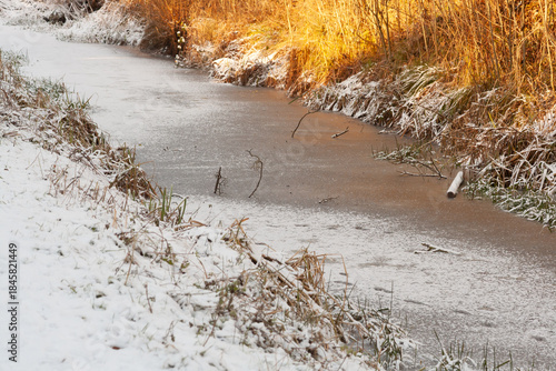 Frozen solid, stream in countryside frozen solid on a winters day preventing birds and animals from swimming or drinking in it.