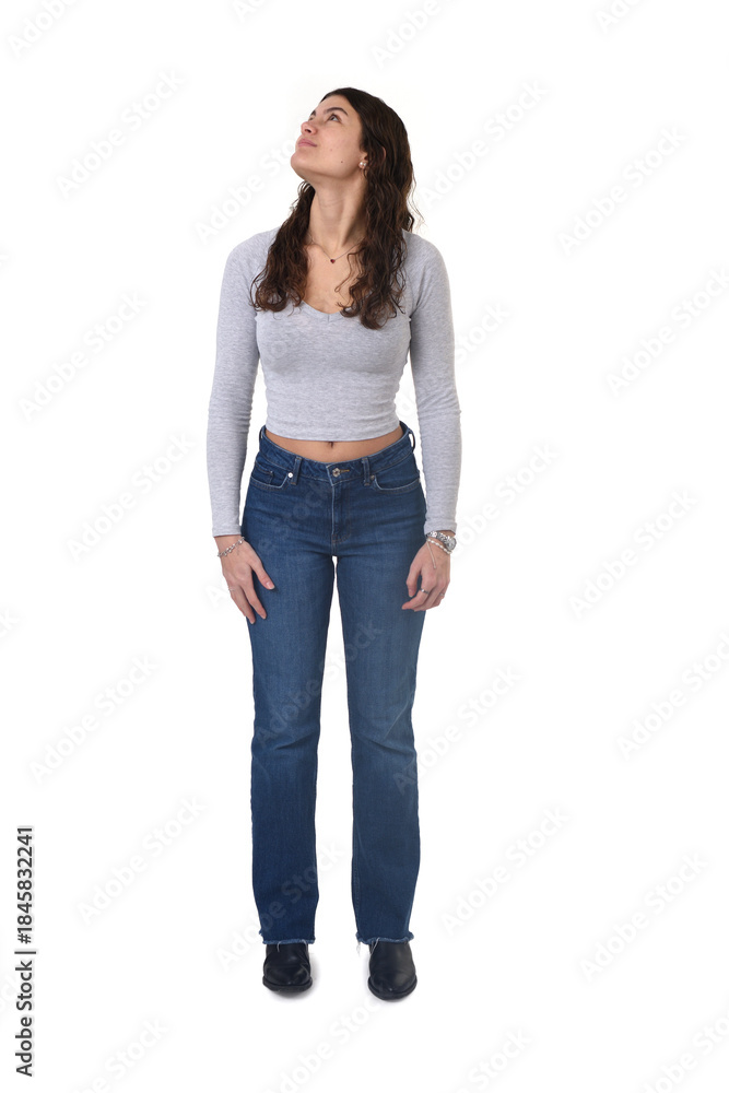 Obraz premium front view portrait of an 18-year-old girl standing, looking up and looking side on white background