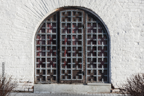 Old metal doors in a white wall.