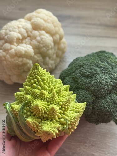 Romanesco cabbage with broccoli and cauliflower on a wooden background