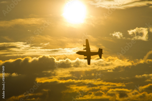 Airplane soaring through vibrant sunset cloudscape freely