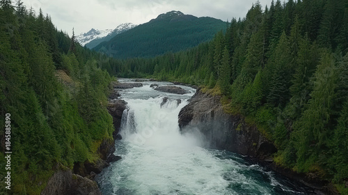 Person meditating beside waterfall lush rocks dynamic water serene forest mountain view
