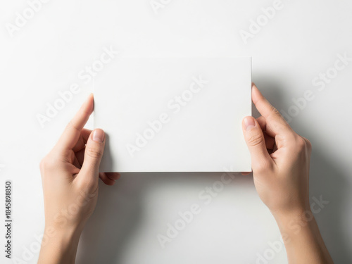 Hands holding a white card isolated on white background