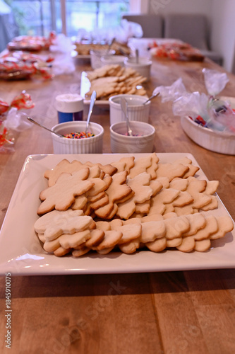 Homemade Christmas sugar cookies set up for themed Daddy Daughter cookie decorating holiday party with sprinkles, icing and coloured sugar