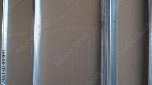 Metal studs and drywall, close-up video capture.