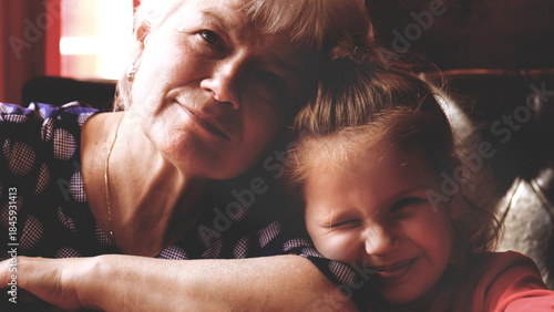 Foto Loving cute granddaughter hugging her grandmother