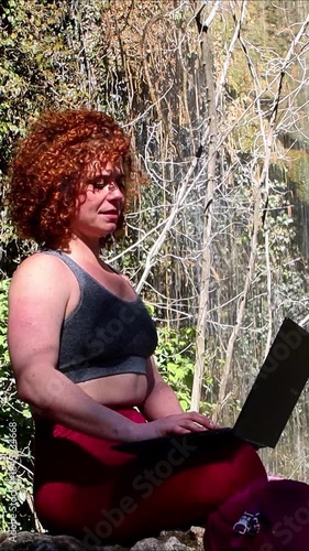 Redhead freelancer closing her laptop after working in nature
