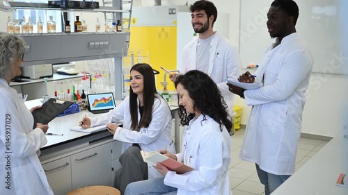 University professor teaching science students in a modern laboratory