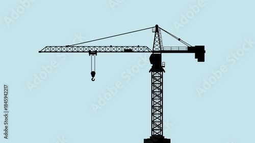 A construction crane stands tall against a clear blue sky with its hook hanging freely.