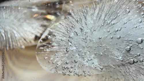 Macro photo showing intricate air bubbles and crystal patterns trapped in clear ice, ideal for backgrounds, science visuals, or abstract nature concepts.