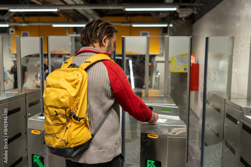Canvas Print Adult man tapping ticket on turnstile entering subway station, public transport