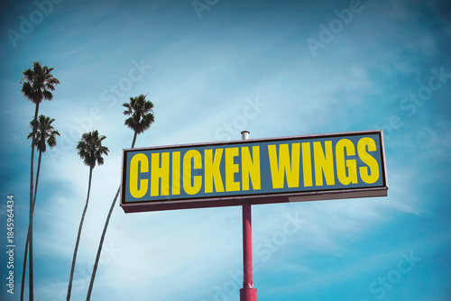 Worn chicken wings sign with palm trees