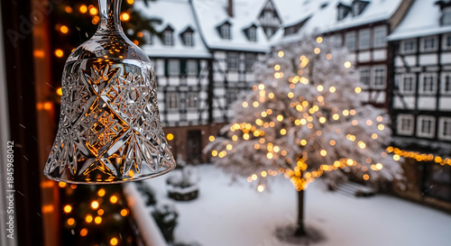 Winter bell decoration with snowy courtyard and illuminated tree  